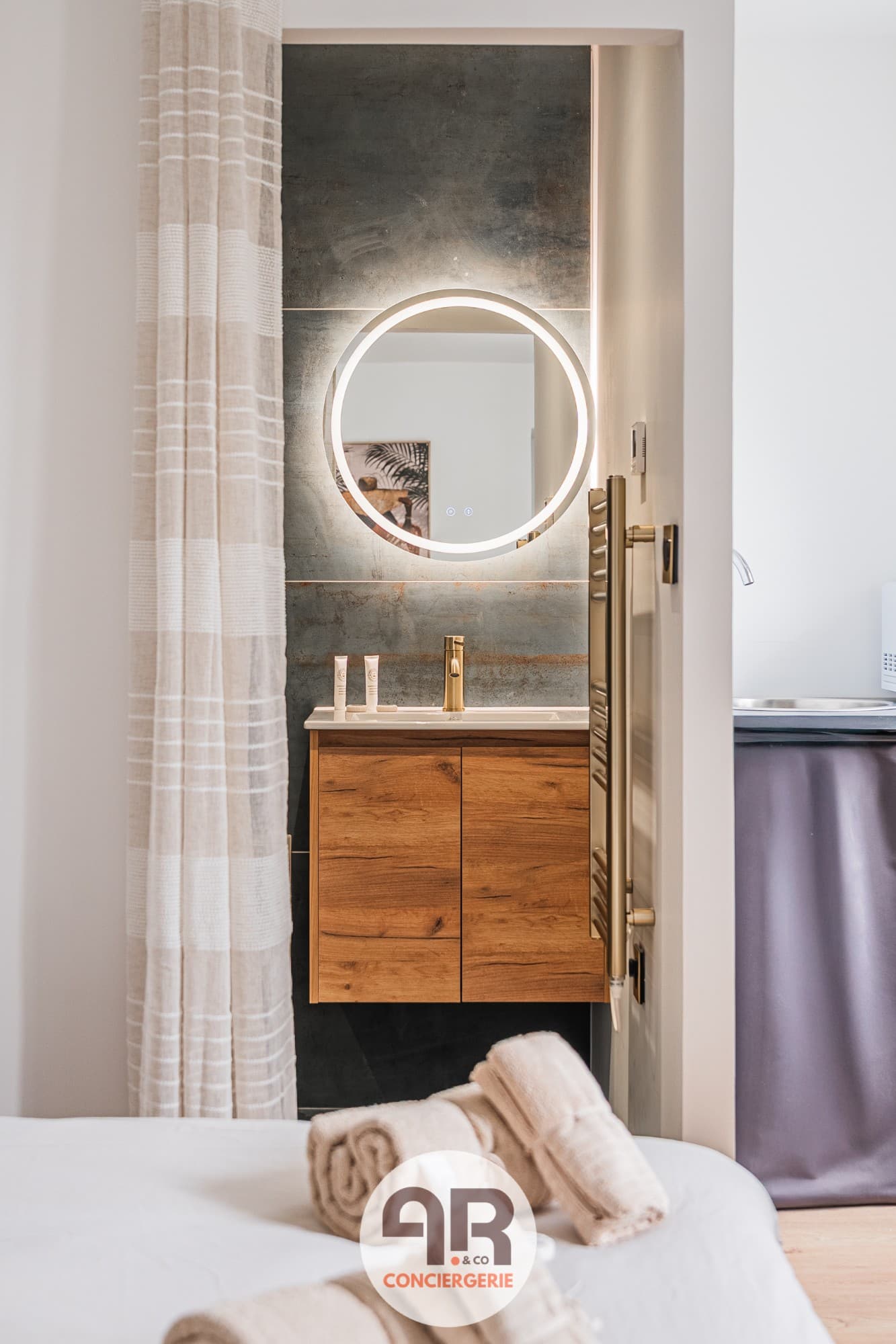 Salle d'eau avec miroir rétroéclairé dans un logement géré par AR&Co